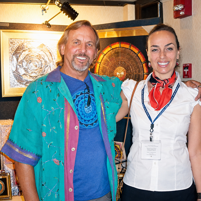 Mandala artist Paul Heussenstamm with Ebru Şinik surrounded by his original artworks
